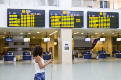 Woman using mobile phone at airport