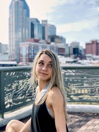 Portrait of smiling young woman in city