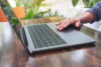 Midsection of man using laptop on table