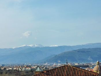 Town by mountains against sky