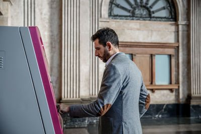 Man using atm machine in city