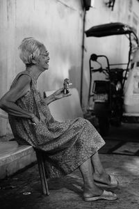 Side view of woman sitting on chair