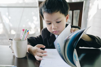 Portrait of boy holding table