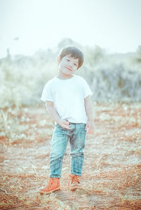 Full length portrait of boy standing on field