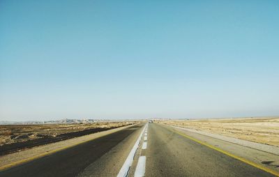 Road against clear blue sky