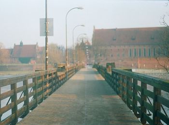 Walkway in city against sky