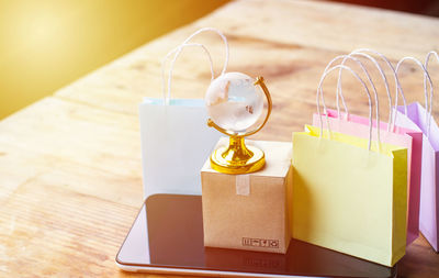 Close-up of shopping bags and mobile phone on table