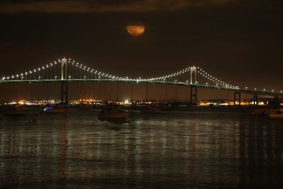 Illuminated suspension bridge against sky at night