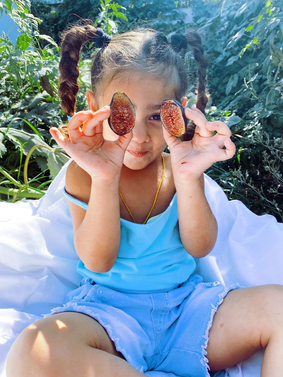 PORTRAIT OF CUTE GIRL HOLDING BABY SITTING OUTDOORS