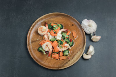 Stir-fried broccoli and shrimp on a black background