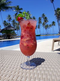 Red wine on table against swimming pool