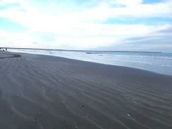 View of beach against cloudy sky