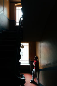 A man is standing by the window in the stairwell