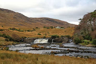 Scenic view of river amidst mountains against sky