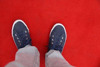 Low section of man wearing shoes on red carpet