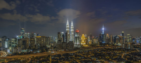 Illuminated cityscape against sky at night