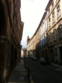 Street amidst buildings against sky in city
