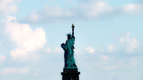 Low angle view of statue of liberty against cloudy sky