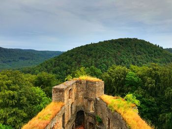 Castle on mountain against cloudy sky