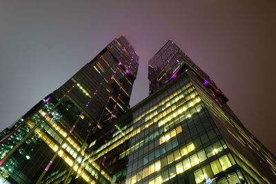 Low angle view of illuminated buildings against sky at night