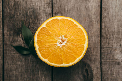 Sliced halves of orange fruit on gray wooden background. pulp and green leaves. high quality photo