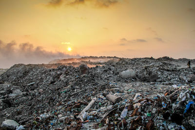 Garbage on mountain against sky during sunset