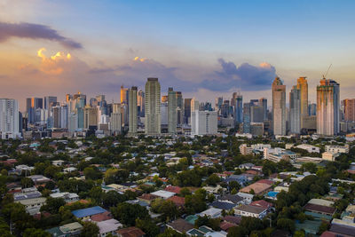 Aerial view of buildings in city against sky during sunset