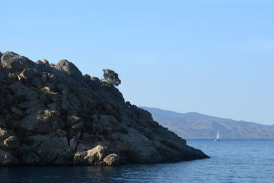 Scenic view of sea and mountains against clear blue sky