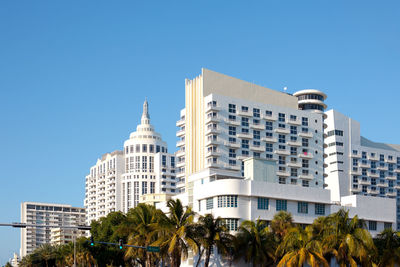 Low angle view of modern buildings against blue sky