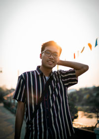 Portrait of young man standing against clear sky during sunset