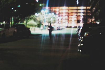 People walking on illuminated street at night