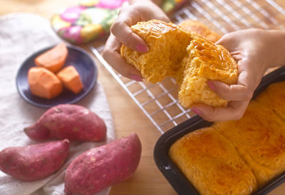 High angle view of person holding bread on table