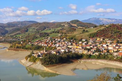 Scenic view of townscape by mountains against sky