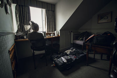 Rear view of man sitting in room