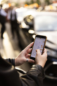 Woman operating map through smart phone in city