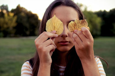 Close-up of woman holding yellow flower