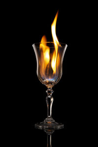 Close-up of lit candle against black background