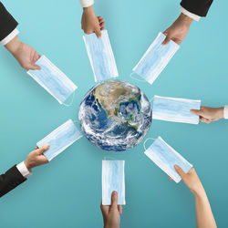 Low section of people holding hands against blue background