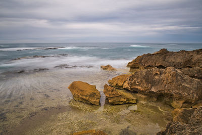 Rocks on beach against sky