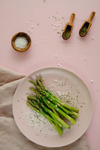 High angle view of green asparagus on plate on table. 