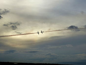 Low angle view of silhouette airplane flying in sky