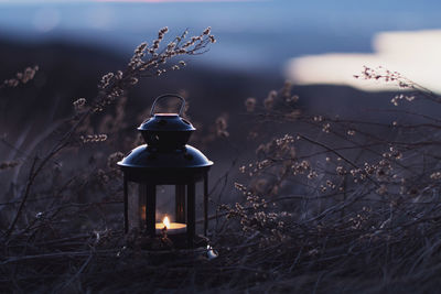 Illuminated electric lamp on field against sky