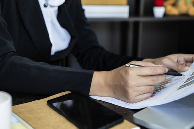 Midsection of man sitting on table