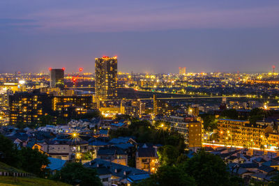 Illuminated cityscape against sky at night