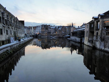 Canal amidst buildings in city against sky