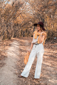 Young woman wearing hat against trees