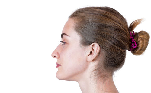 Close-up portrait of a young woman over white background