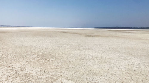 Surface level of beach against clear sky