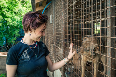 Dog at the shelter.  lonely dogs in cage with cheerful woman volunteer