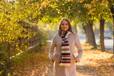 Portrait of woman standing against trees